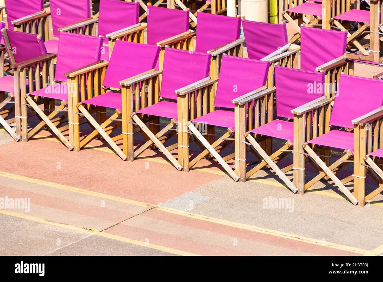 Reihen von purpurnen Stühlen mit Stoffregisseuren in Eastbourne Stockfoto