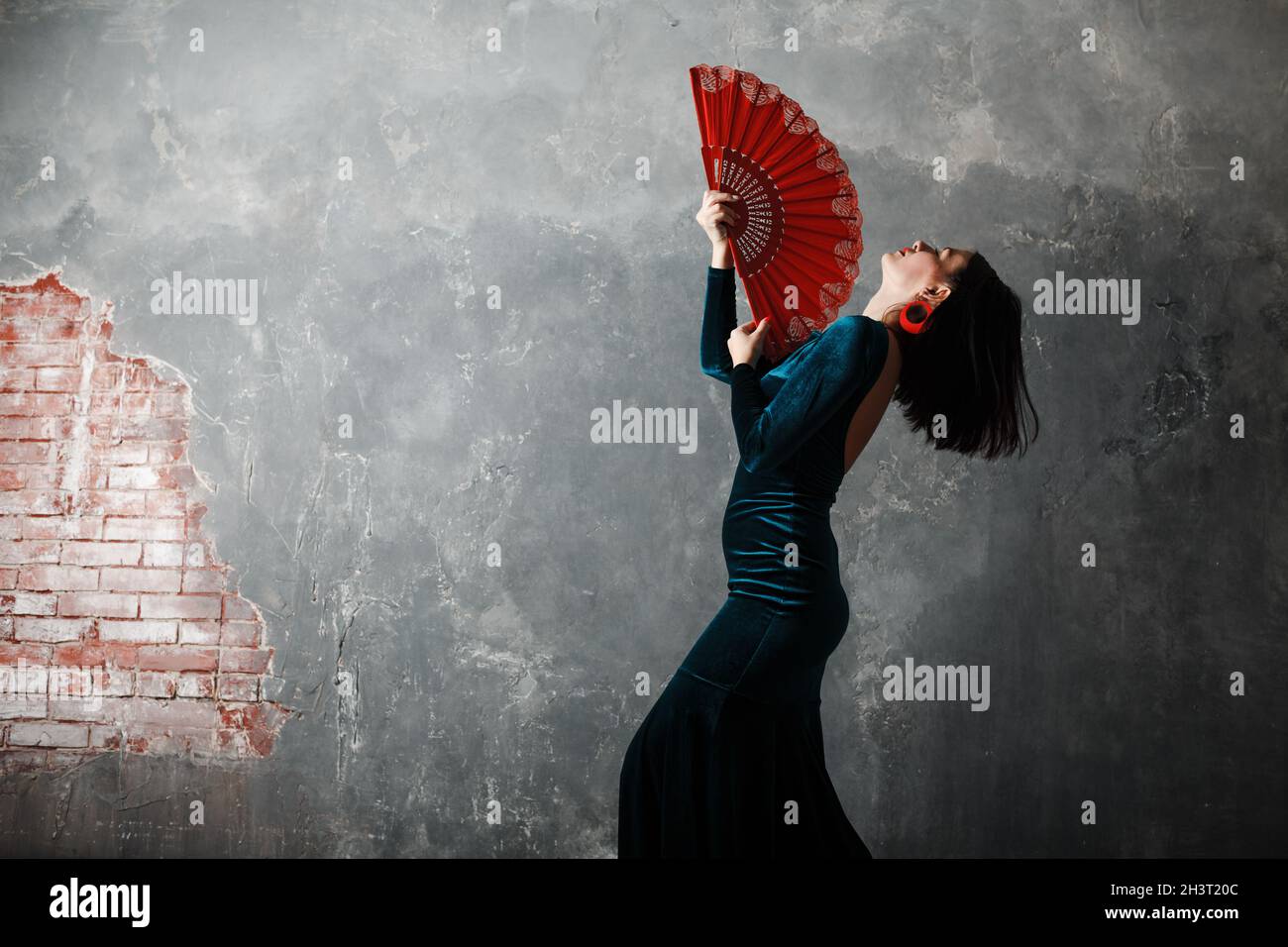 Tänzerin tanzt Flamenco auf grauem Vintage-Studio-Hintergrund. Stockfoto