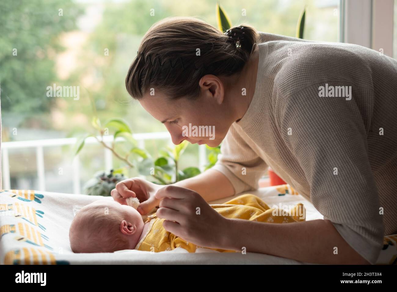 Kaukasische Mutter ändert Baby Mädchen sauberes Tuch Stockfoto