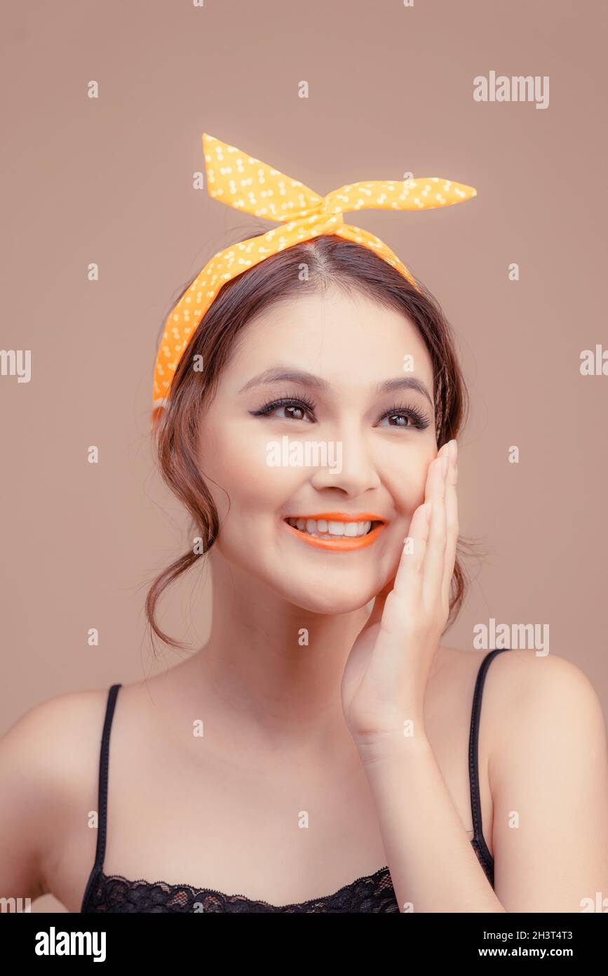 Porträt von schönen schönen jungen Frau zärtlich flirtet lächelnd, Handfläche in der Nähe der Wange isoliert über rosa Hintergrund Stockfoto