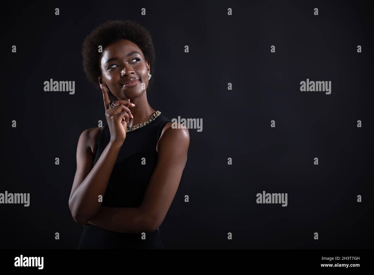 Junge schwarze Frau versucht, die beste Lösung zu finden. afroamerikanische Frau mit zweifelhaftem Ausdruck, die Seite weg schaut und hält Stockfoto