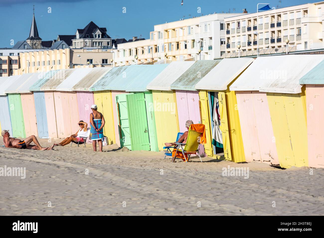 Menschen genießen die Sonne an bunten Strandhütten. Berck-Plage. Opal Coast, Frankreich Stockfoto