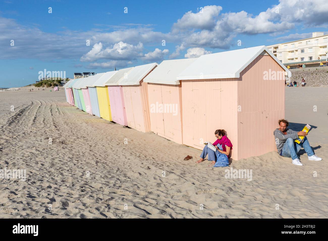 Menschen genießen die Sonne an bunten Strandhütten. Berck-Plage. Opal Coast, Frankreich Stockfoto