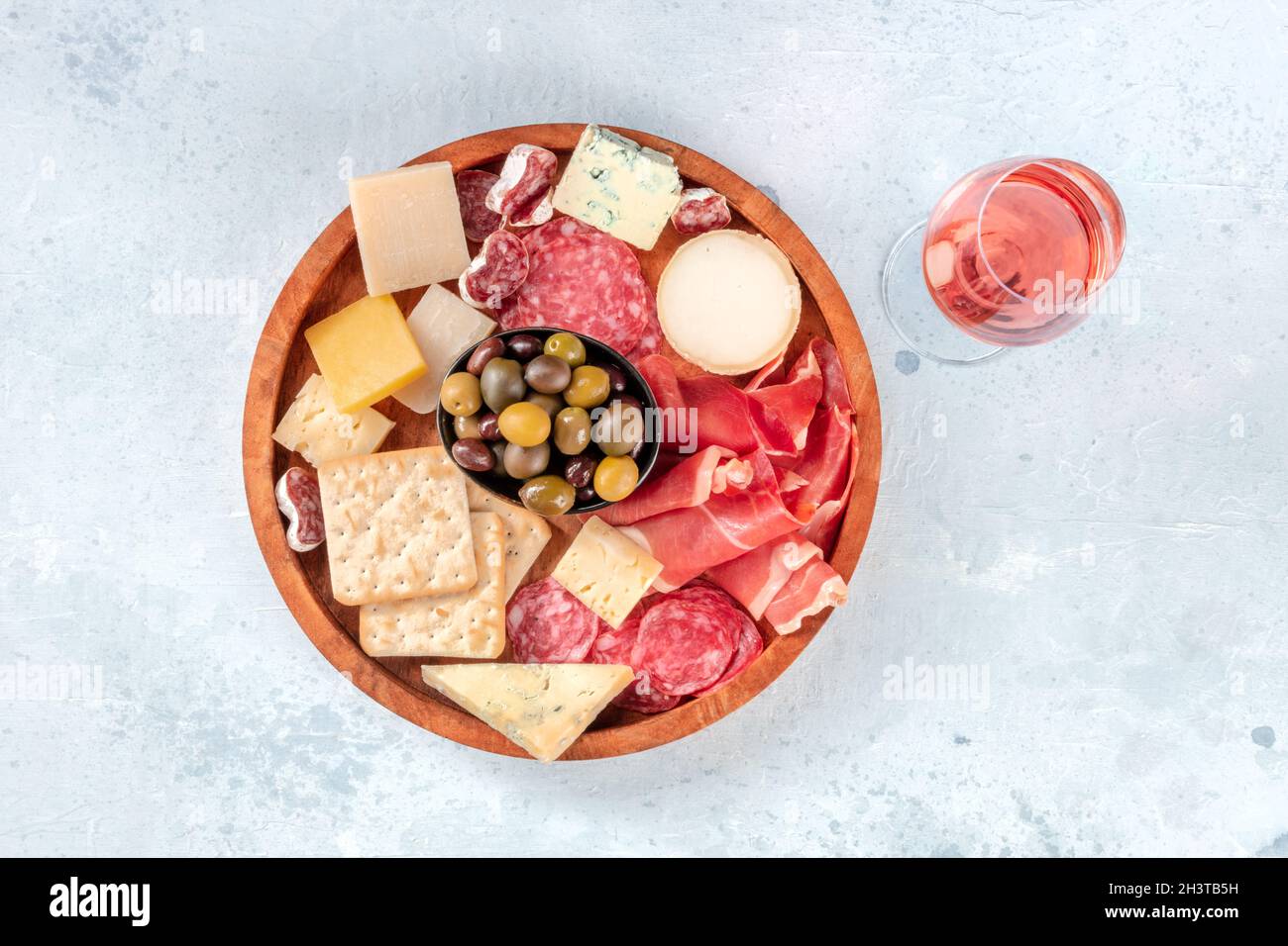 Wurstwaren und Käseplatte, von oben mit einem Glas Rosenwein geschossen Stockfoto