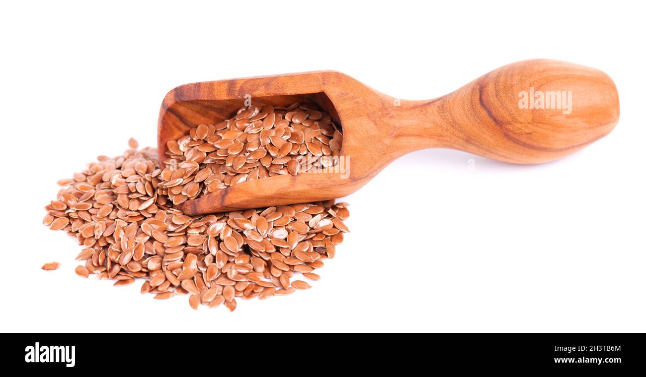 Braune Leinsamen in Holzlöffel, isoliert auf weißem Hintergrund. Haufen trockener Leinsamen oder Leinsamen. Stockfoto