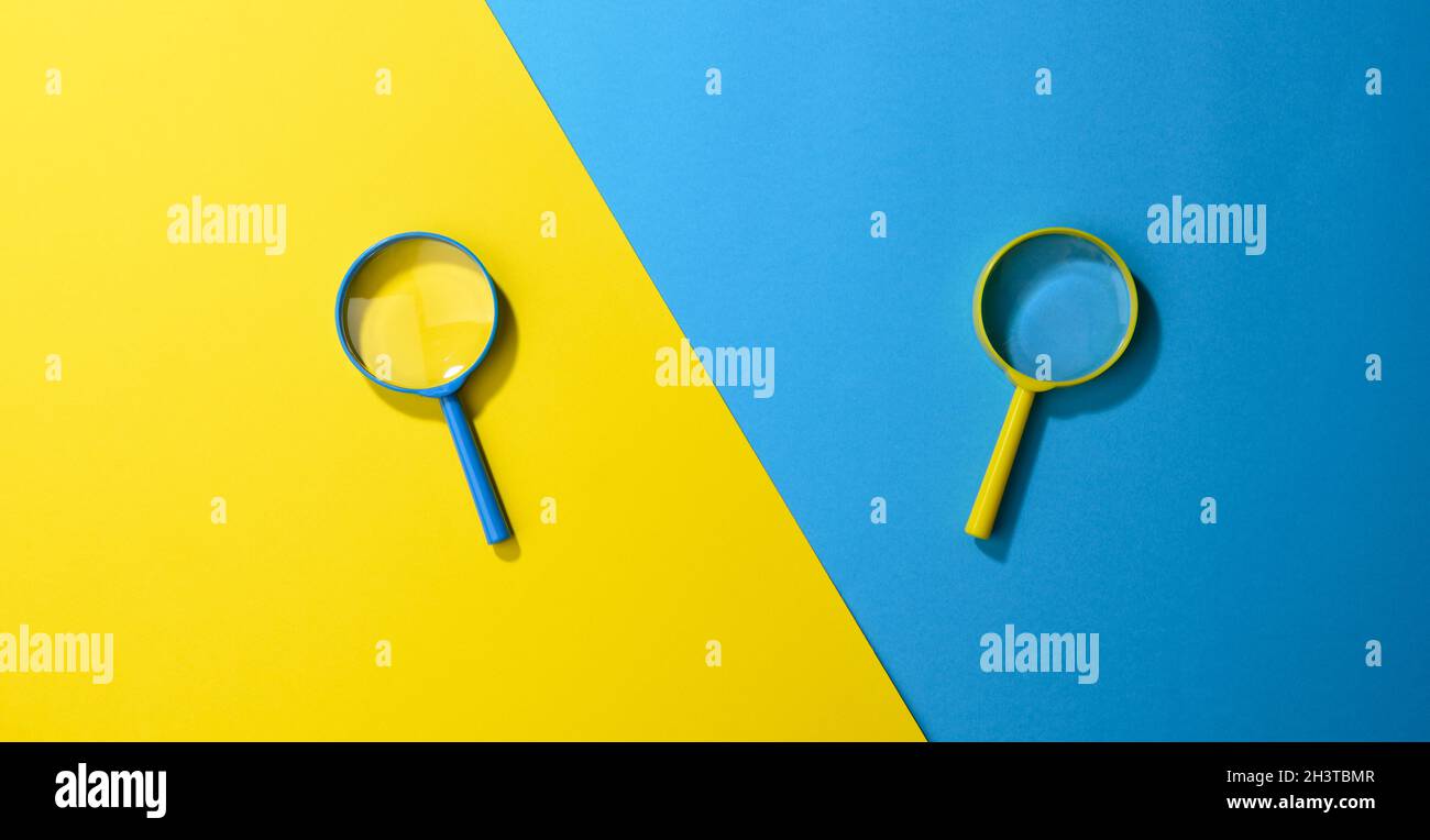 Zwei Plastiklupen auf gelb-blauem Hintergrund Stockfoto