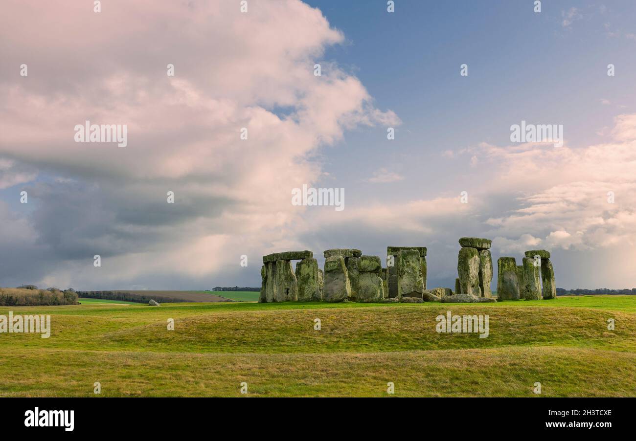 Stonehenge, prähistorisches Monument, umgeben von Grasland und unter wolkig-sonnigen Winterhimmen und ohne Menschen in Amesbury, Wiltshire, Großbritannien. Stockfoto