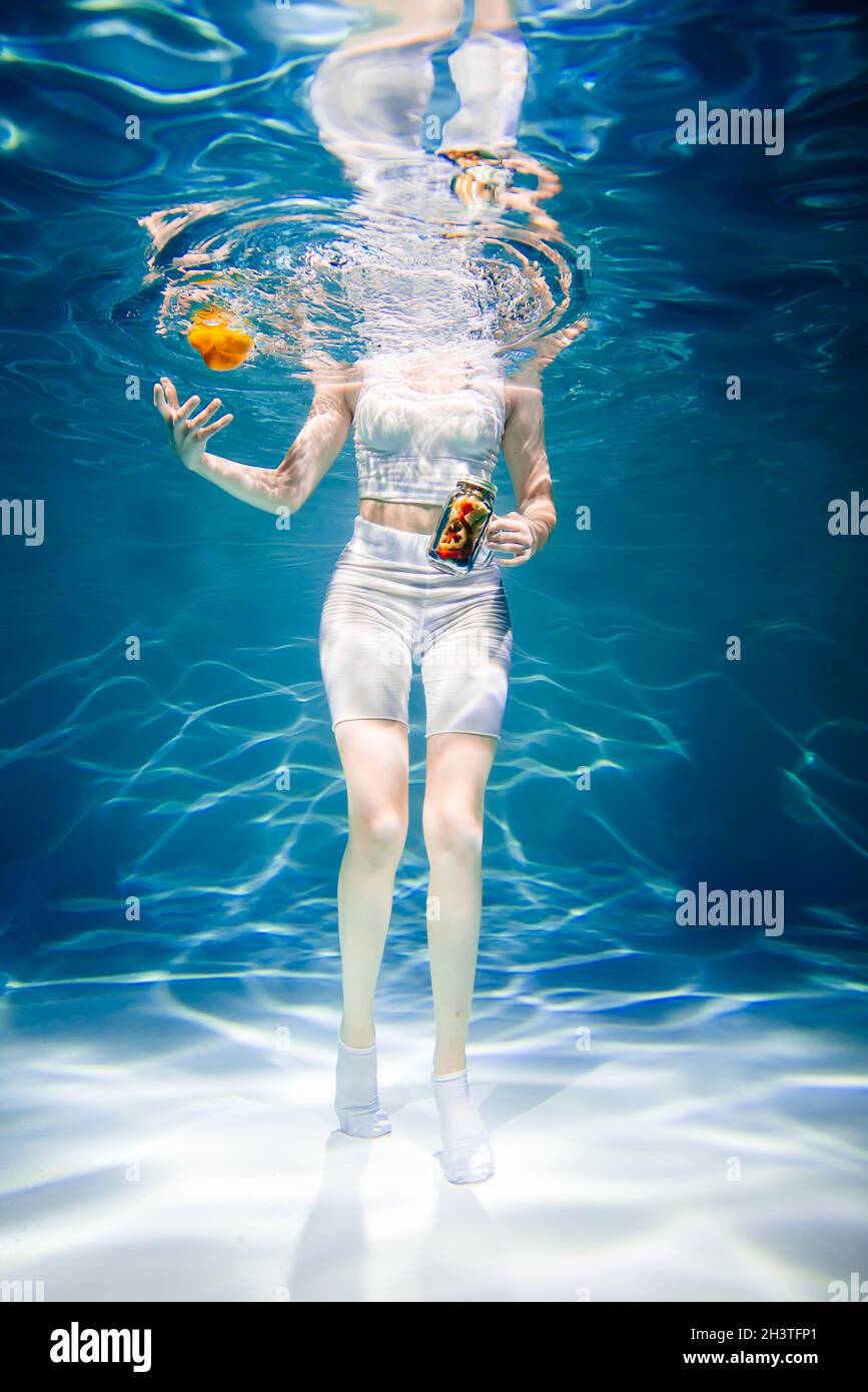 Mädchen auf blau ohne Gesicht mit Gemüse unter Wasser, Frau gesunde Ernährung Konzept Stockfoto
