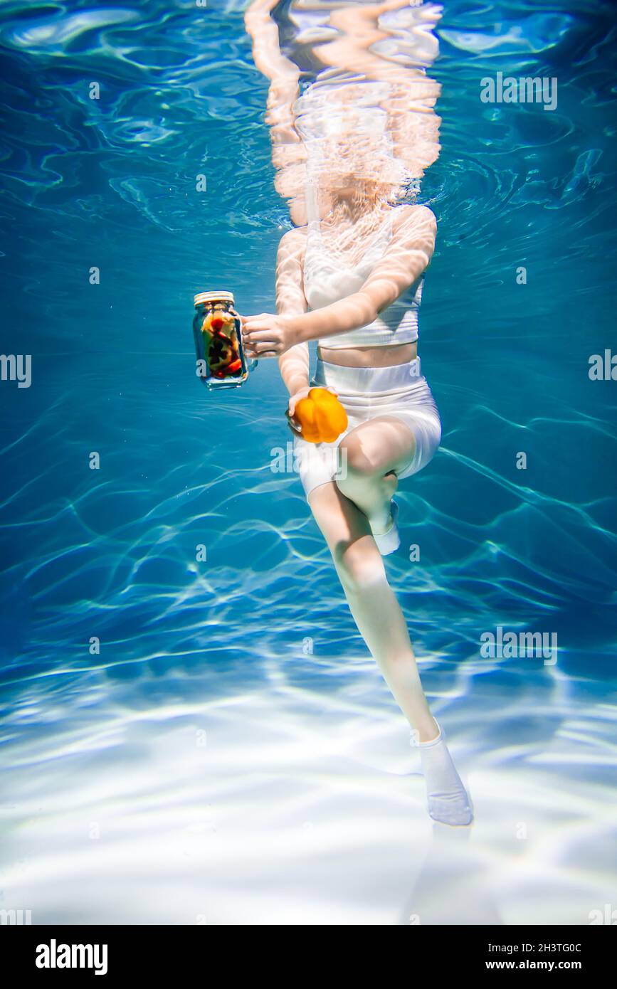 Mädchen auf blau ohne Gesicht mit Gemüse unter Wasser, Frau gesunde Ernährung Konzept Stockfoto