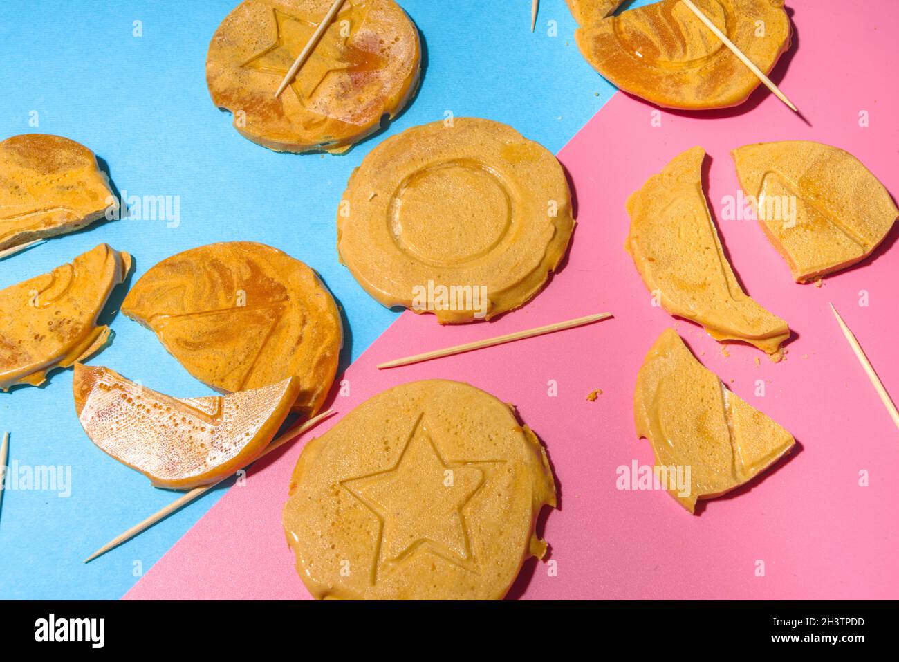 Worldwide Craze Trending Game, Squid Game TV-Serie, Koreanische Cookies -  Dalgona Sweets Candy Challenge, auf hellem, hochfarbigem, pinkblauen  Hintergrund flach Stockfotografie - Alamy