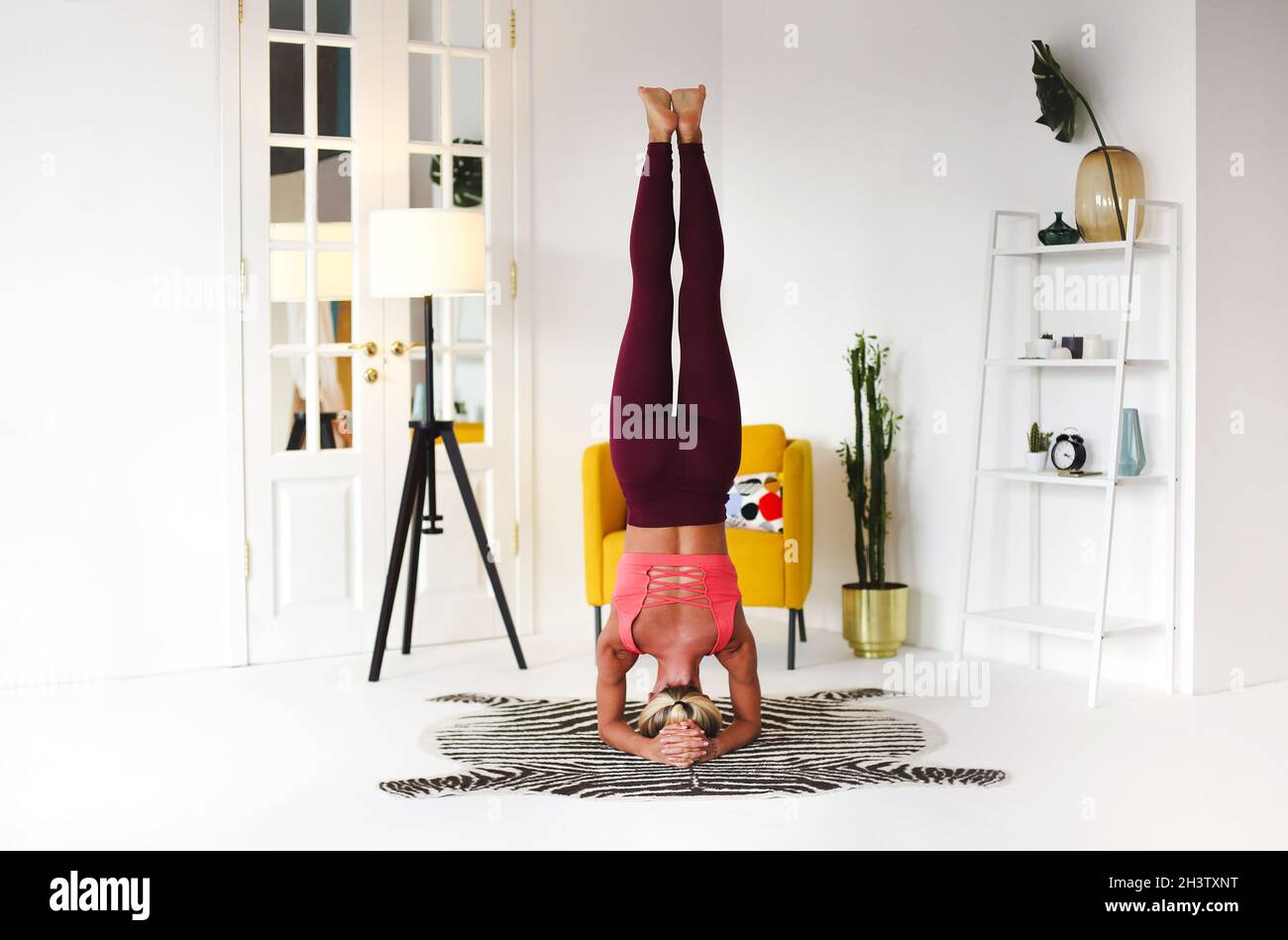 Schlanke Frau tut Balancing Handstand Asana Stockfoto