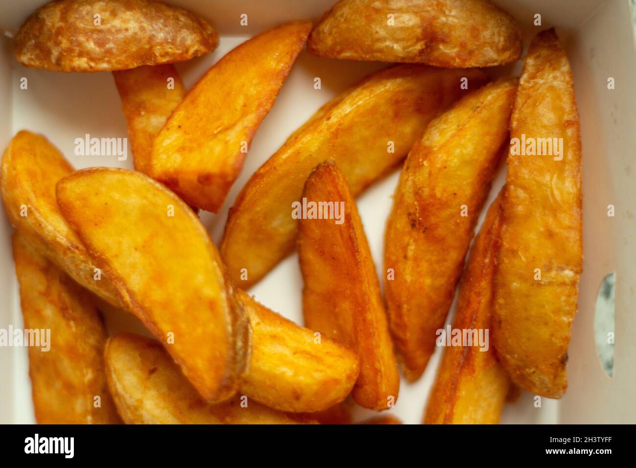 Die Textur der Kartoffeln ist rustikal. Chips. Fetthaltige Lebensmittel. Details zu Fast Food. Stockfoto