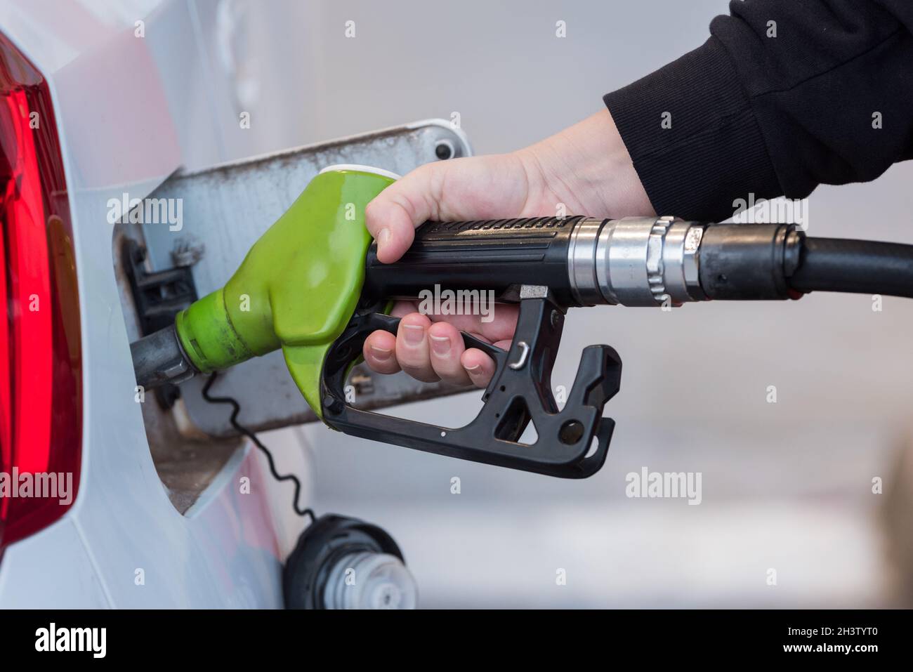 Nahaufnahme einer Frau, die an der Tankstelle Gas in ihr Auto füllt. Transport, Umwelt, Brennstoffe. Stockfoto