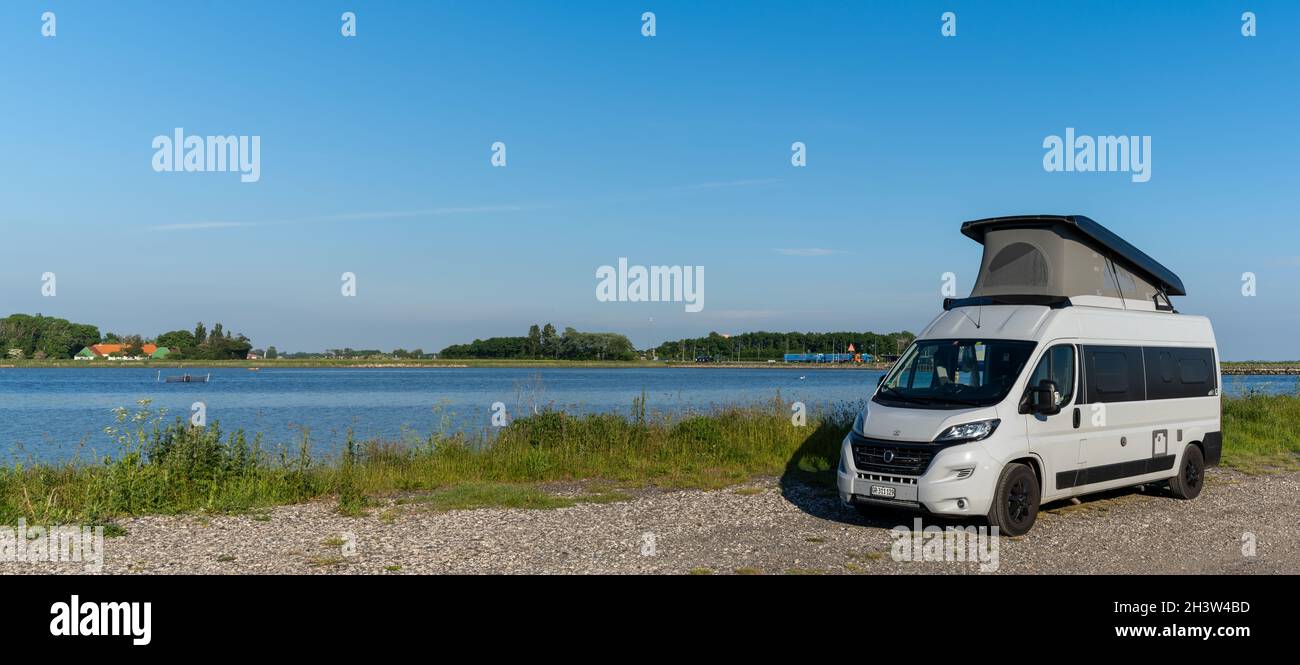 Grauer Wohnmobil parkte auf einer Schotterstraße am Meeresufer der Insel Lolland im Süden Dänemarks Stockfoto