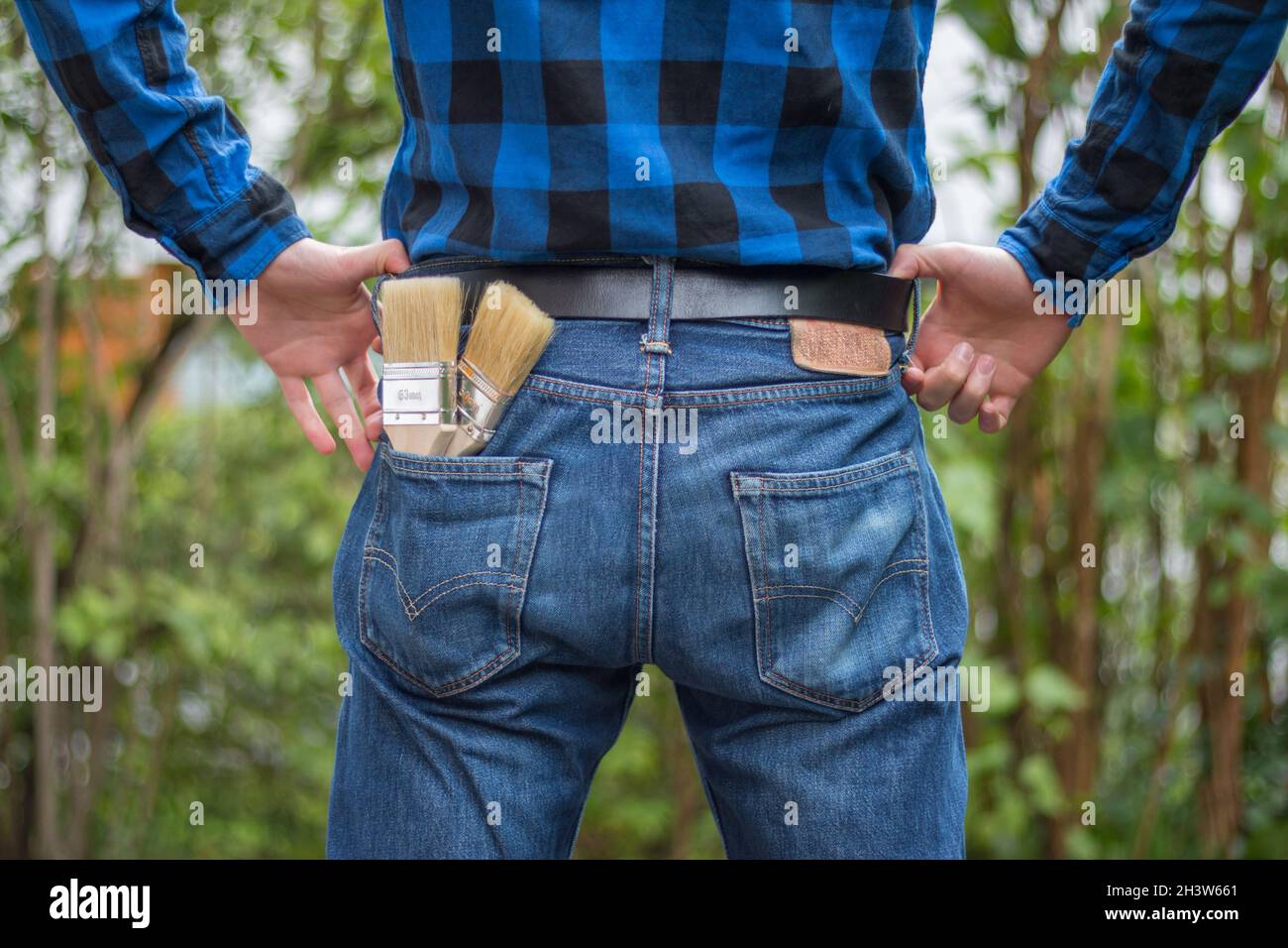 Heimwerker: Rückansicht eines jungen Mannes mit Pinsel in der Tasche Stockfoto