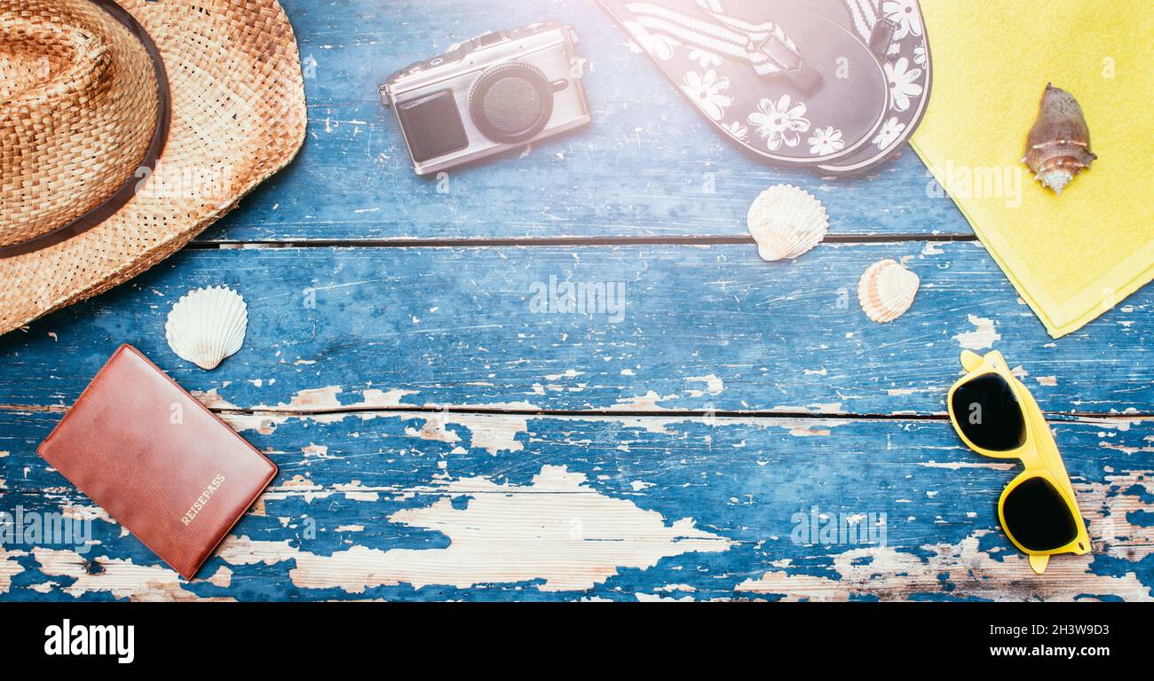 Urlaubskonzept: Vintage Holztisch mit Urlaubszubehör: Strohhut, Sonnenbrille, Muscheln, Vintage-Kamera, Pass und Flip f Stockfoto