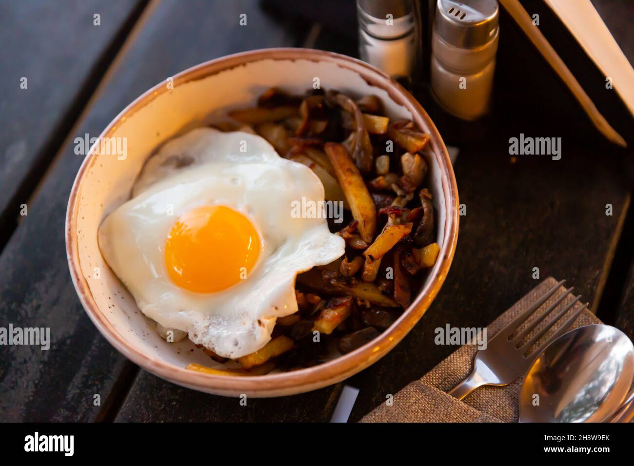 Spiegelei mit gebackenen Kartoffeln mit Aubergine und Pfeffer Stockfoto
