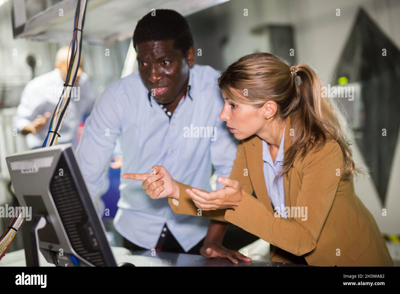 Mann und Frau in Angst auf der Suche nach einer Lösung auf dem Computer im Quest-Zimmer Stockfoto