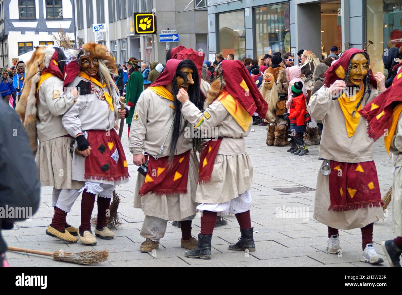 Leute in lustigen Kleidern und Masken, die den traditionellen deutschen Shrovetide-Karneval namens Fasching oder Narrensprung in Ulm feiern Stockfoto