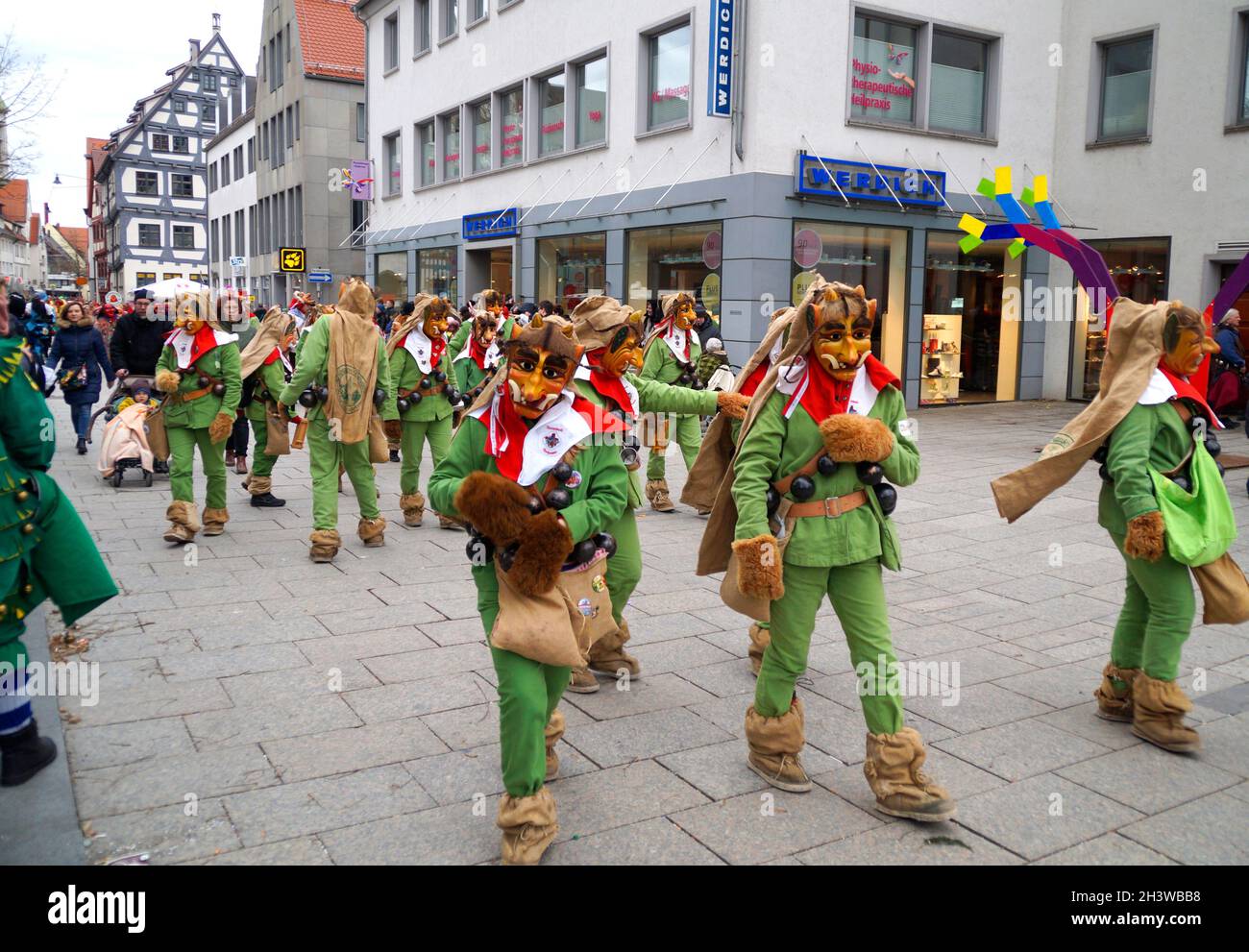 Leute in lustigen Kleidern und Masken, die den traditionellen deutschen Shrovetide-Karneval namens Fasching oder Narrensprung in Ulm feiern Stockfoto