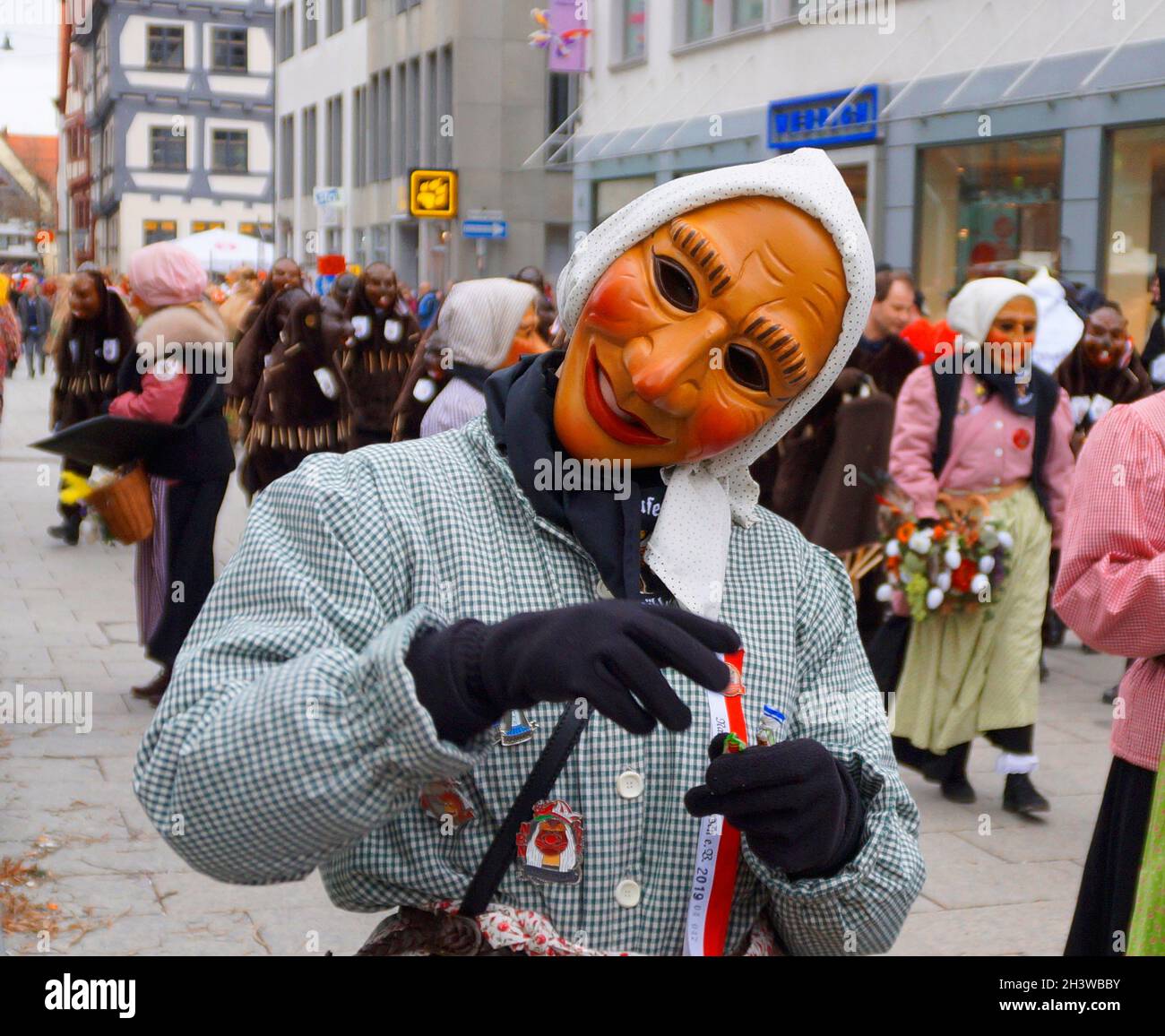 Leute in lustigen Kleidern und Masken, die den traditionellen deutschen Shrovetide-Karneval namens Fasching oder Narrensprung in Ulm feiern Stockfoto