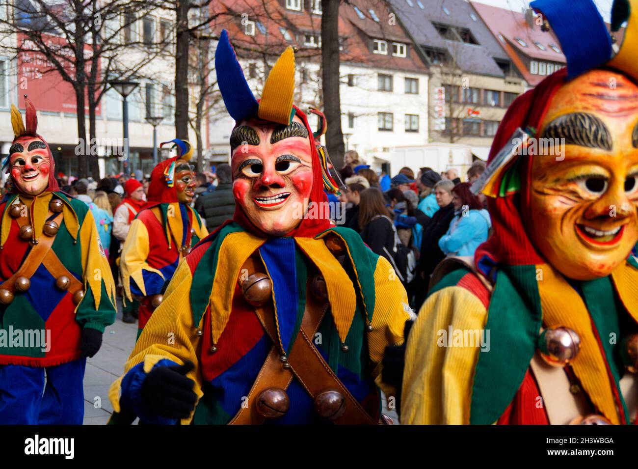 Leute in lustigen Kleidern und Masken, die den traditionellen deutschen Shrovetide-Karneval namens Fasching oder Narrensprung in Ulm feiern Stockfoto