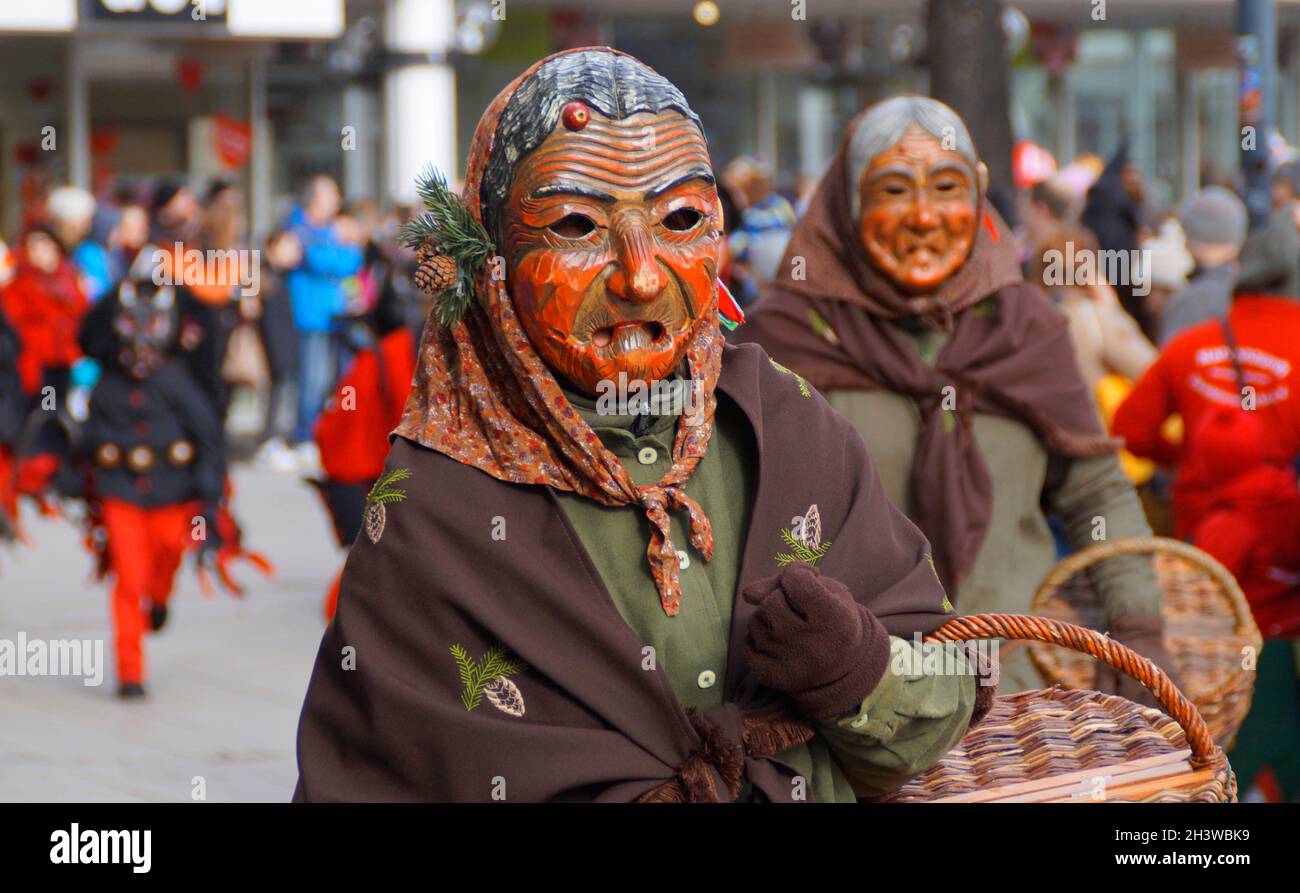 Leute in lustigen Kleidern und Masken, die den traditionellen deutschen Shrovetide-Karneval namens Fasching oder Narrensprung in Ulm feiern Stockfoto