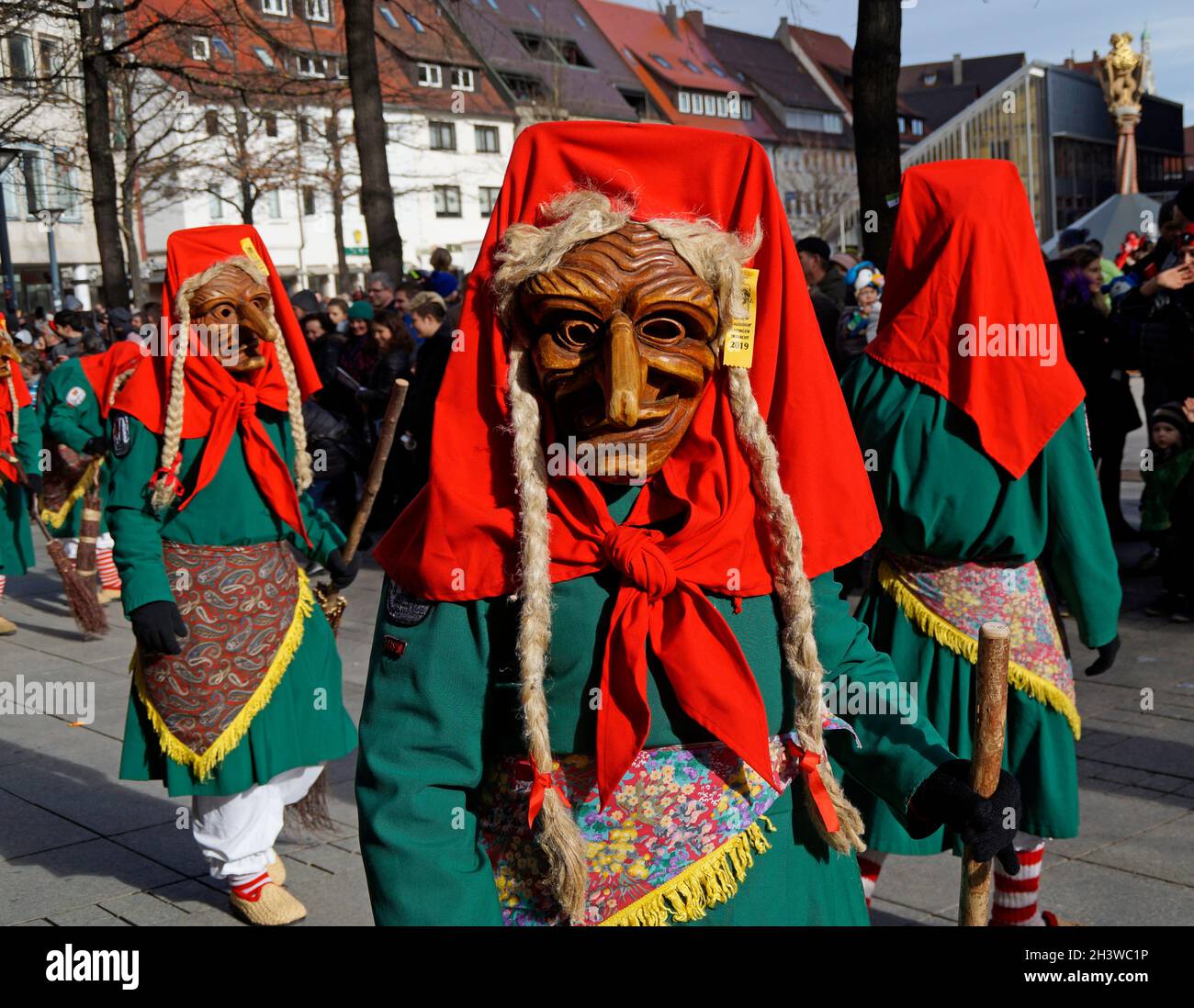 Leute in lustigen Kleidern und Masken, die den traditionellen deutschen Shrovetide-Karneval namens Fasching oder Narrensprung in Ulm feiern Stockfoto