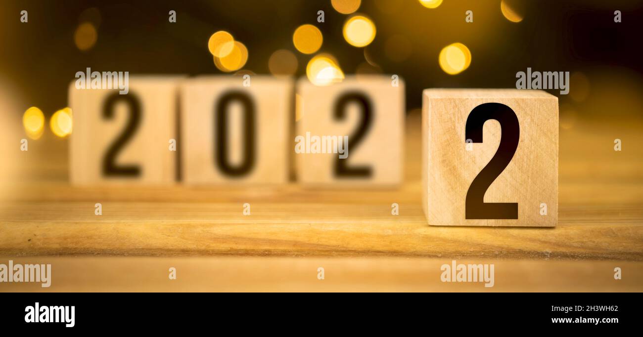 Holzblöcke mit 2022 Nummern auf dem Tisch. Bokeh-Hintergrundbild Stockfoto