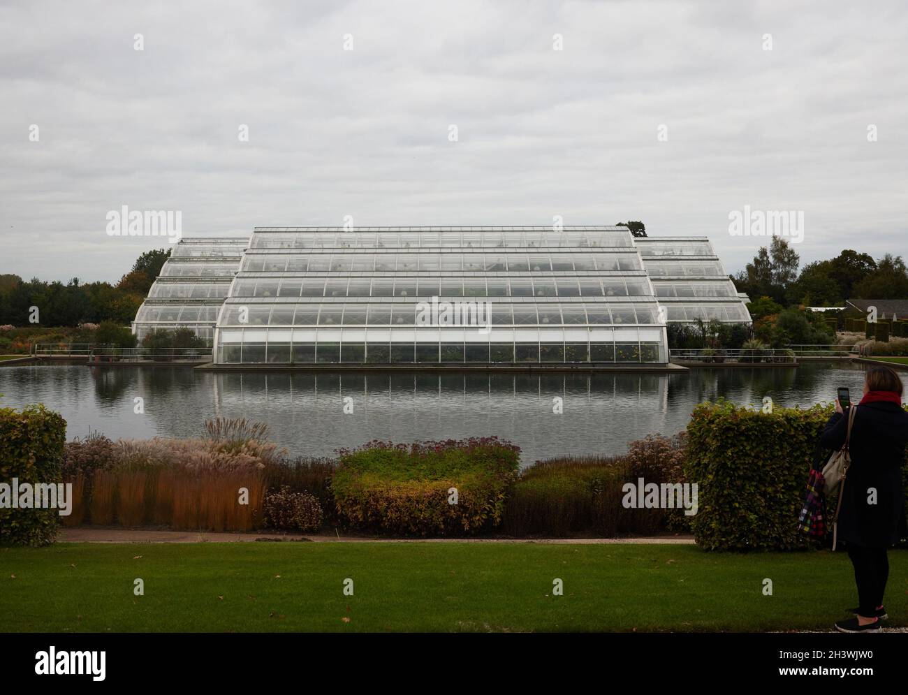 Blick auf das Glashaus der RHS Wisley und den See im Oktober 2021. Stockfoto