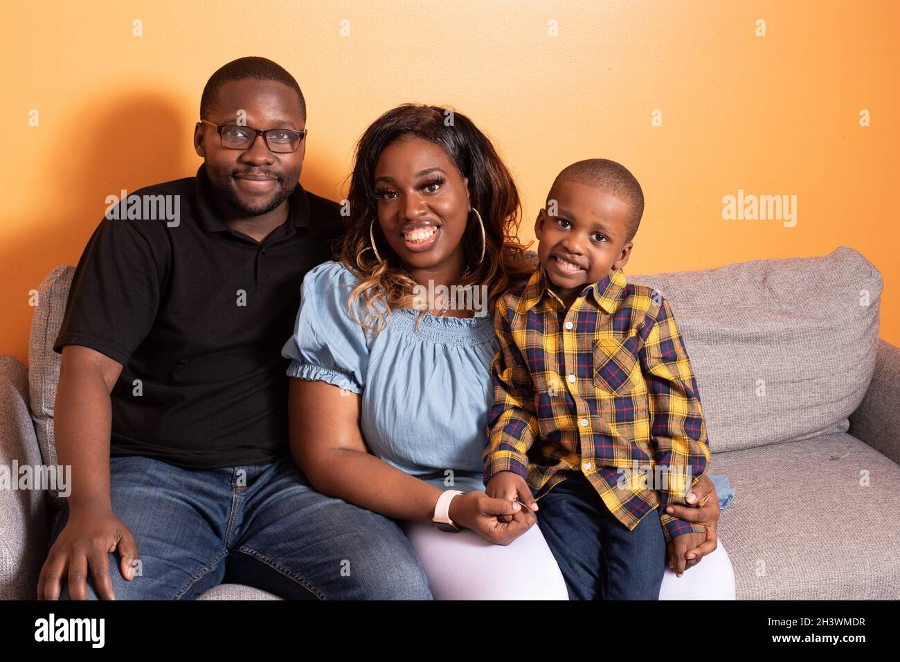 Vorschulkind zu Hause mit den Eltern, posiert für Familienportrait Stockfoto