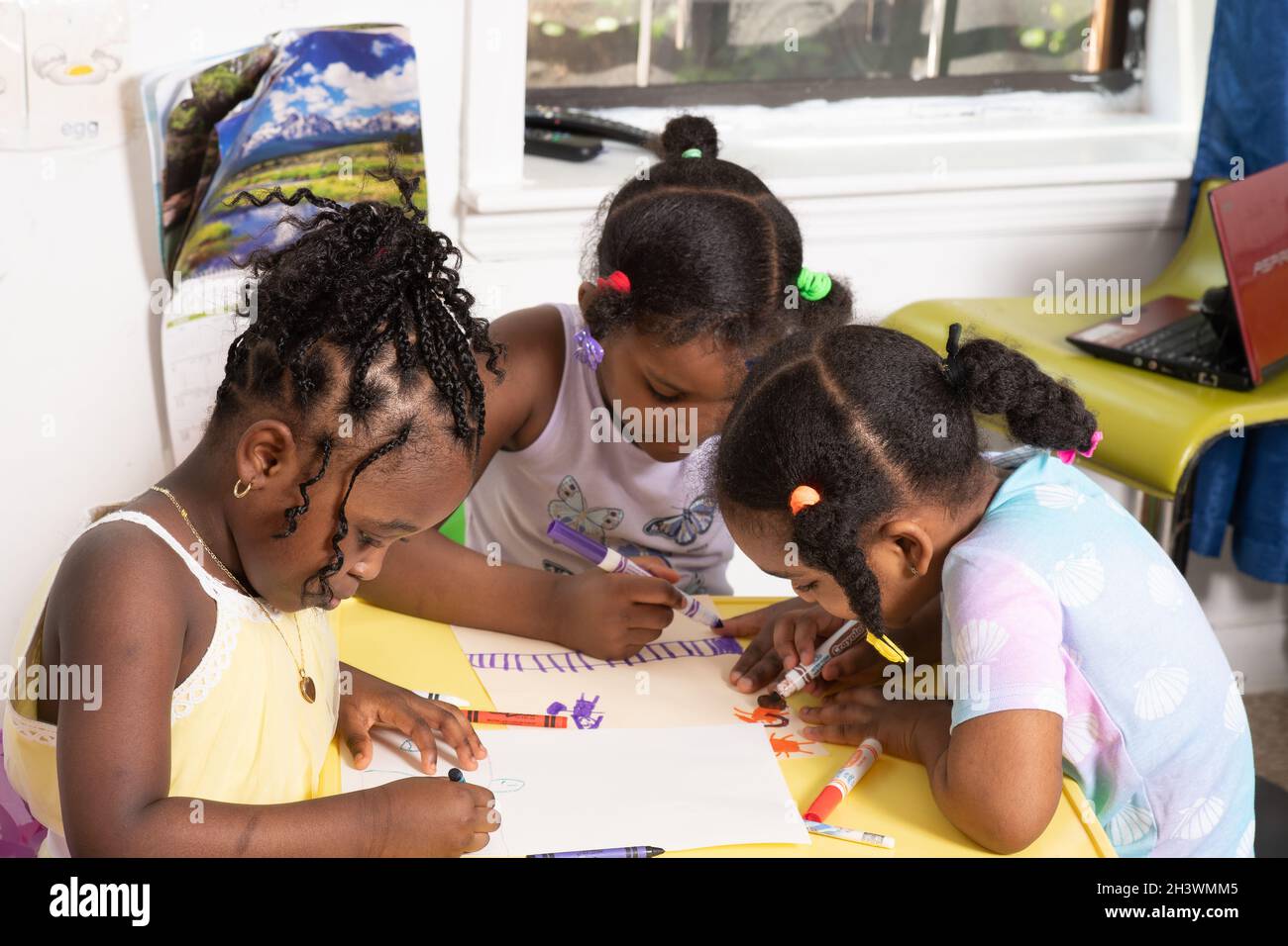3 Mädchen zeichnen mit Buntstiften und Markern am Tisch in der Kindertagesstätte im Alter von 4-6 Jahren Stockfoto