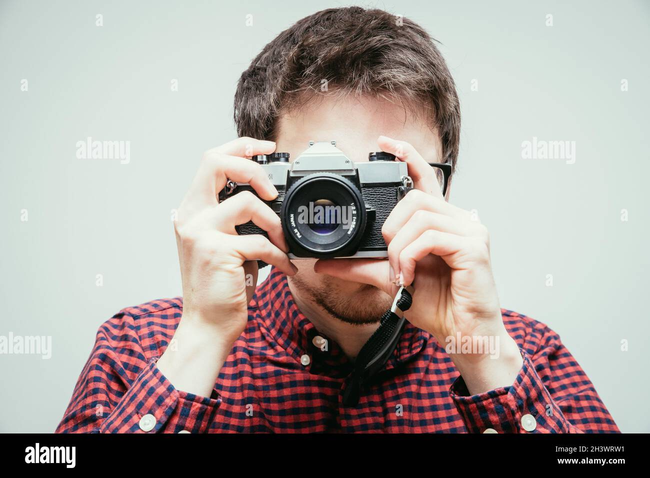 Der junge Mann macht ein Foto mit einer Vintage-Kamera Stockfoto