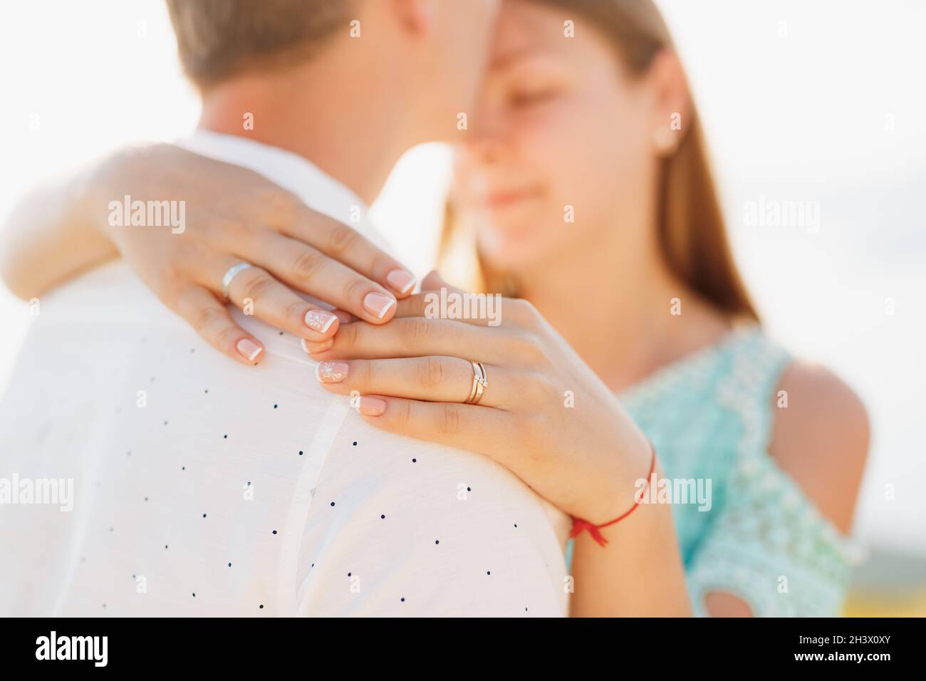 Zwei Liebende, eine Frau umarmt einen Mann, ihre Hände auf den Schultern aus der Nähe Stockfoto