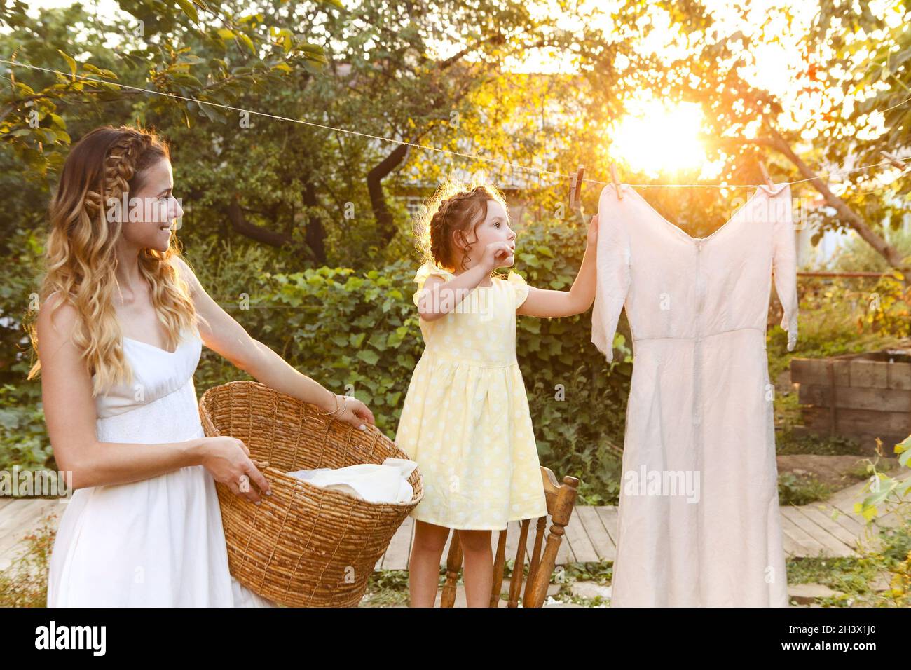 Mutter und Tochter hängen Wäsche im Hinterhof Stockfoto