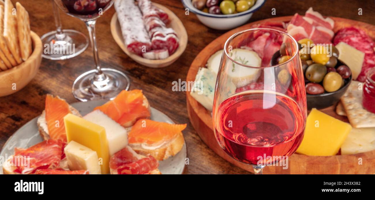 Gourmet Wein Vorspeisen Panorama mit einem Glas Rosé Wein, ein Käseplatte Stockfoto