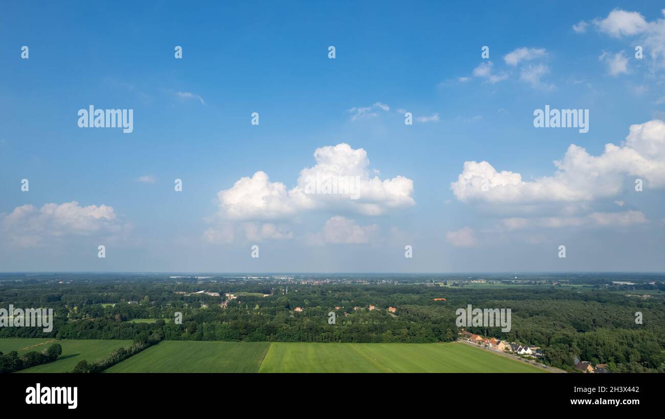 Land oder Landschaft von grünen Feldern in Luftaufnahme. Einschließlich Landwirtschaft Bauernhof, Hausbau, Dorf. Diese Immobilie oder Immobilie Stockfoto