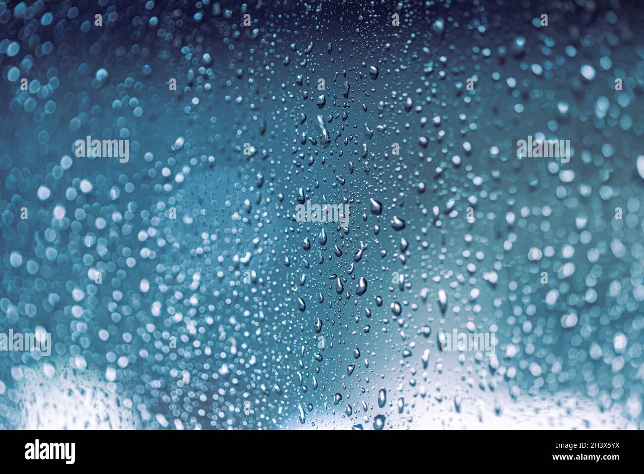 Regen fällt auf das Fenster, regnerische Nacht mit kühlen Lichtern. Abgabemuster. Stockfoto