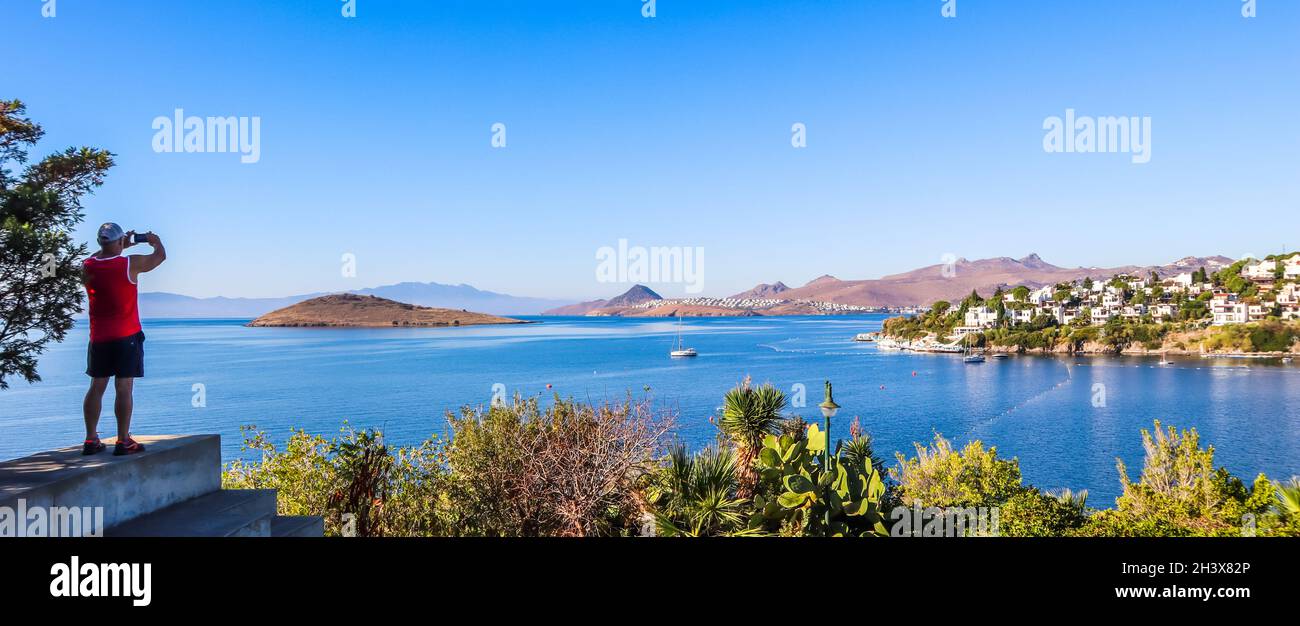 Ein tourist Fotos einen herrlichen Blick auf die wunderschöne Bucht mit ruhigem blauen Wasser. Ruhe und Erholung an der Küste Stockfoto
