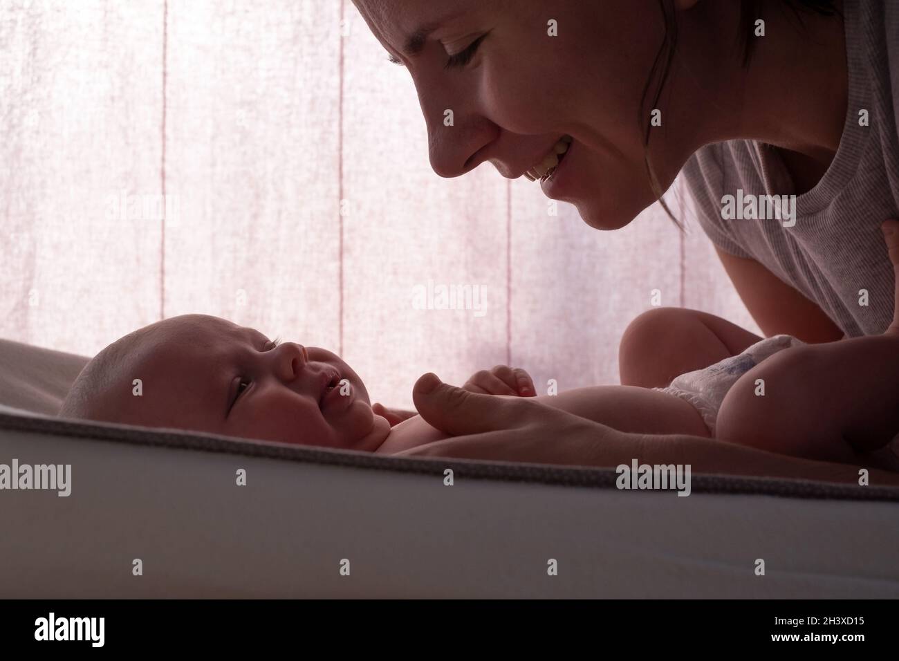 Kaukasische Mutter ändert Baby Mädchen sauberes Tuch Stockfoto