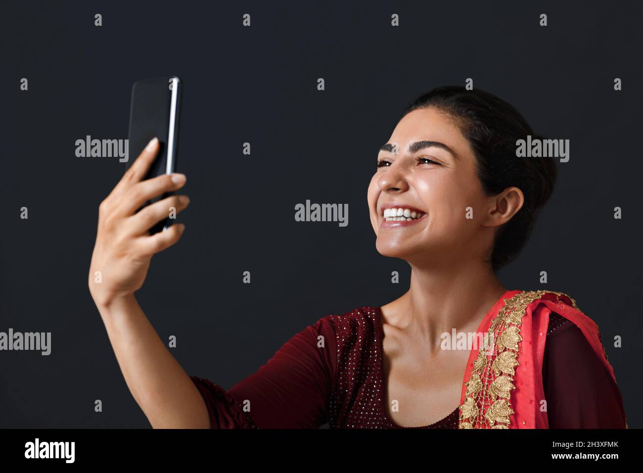 Porträt einer jungen erwachsenen indischen Frau in Sari mit Videoanruf auf dem Mobiltelefon Stockfoto