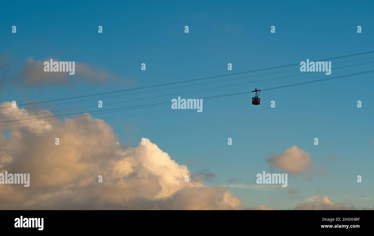 Seilbahn bei Sonnenuntergang. Trolley-Silhouette. Wolkiger Himmel bei Sonnenuntergang. Stockfoto