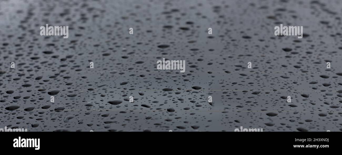 Autoglas mit Tropfen des Fahrers aus dem Regen. Hintergrund löschen. Stockfoto