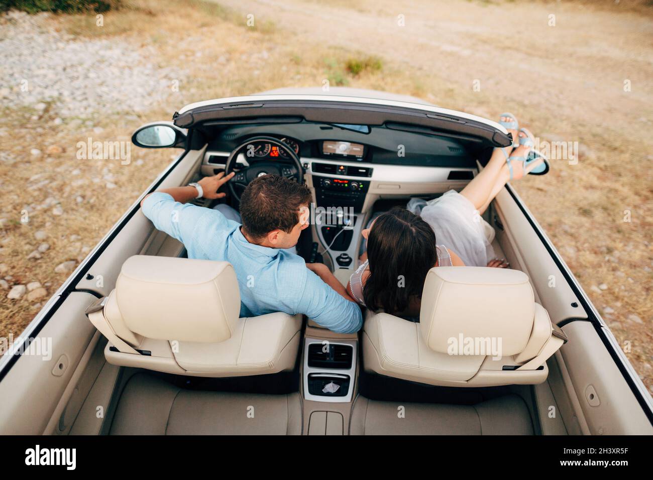 Braut und Bräutigam sitzen im Cabrio Stockfoto