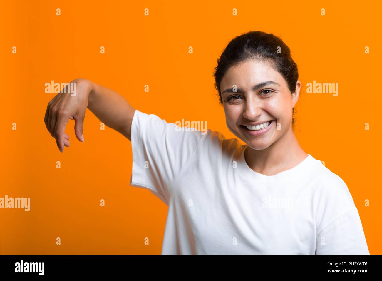 Porträt einer jungen lächelnden erwachsenen indischen Frau mit leerer Handfläche, die etwas Werbevorlage hält. Stockfoto