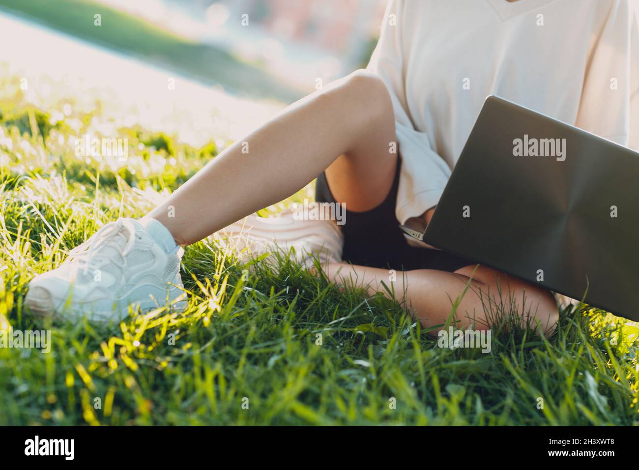 Millenial junge Frau blonde kurze Haare im Freien lächelnd Porträt mit Laptop. Stockfoto