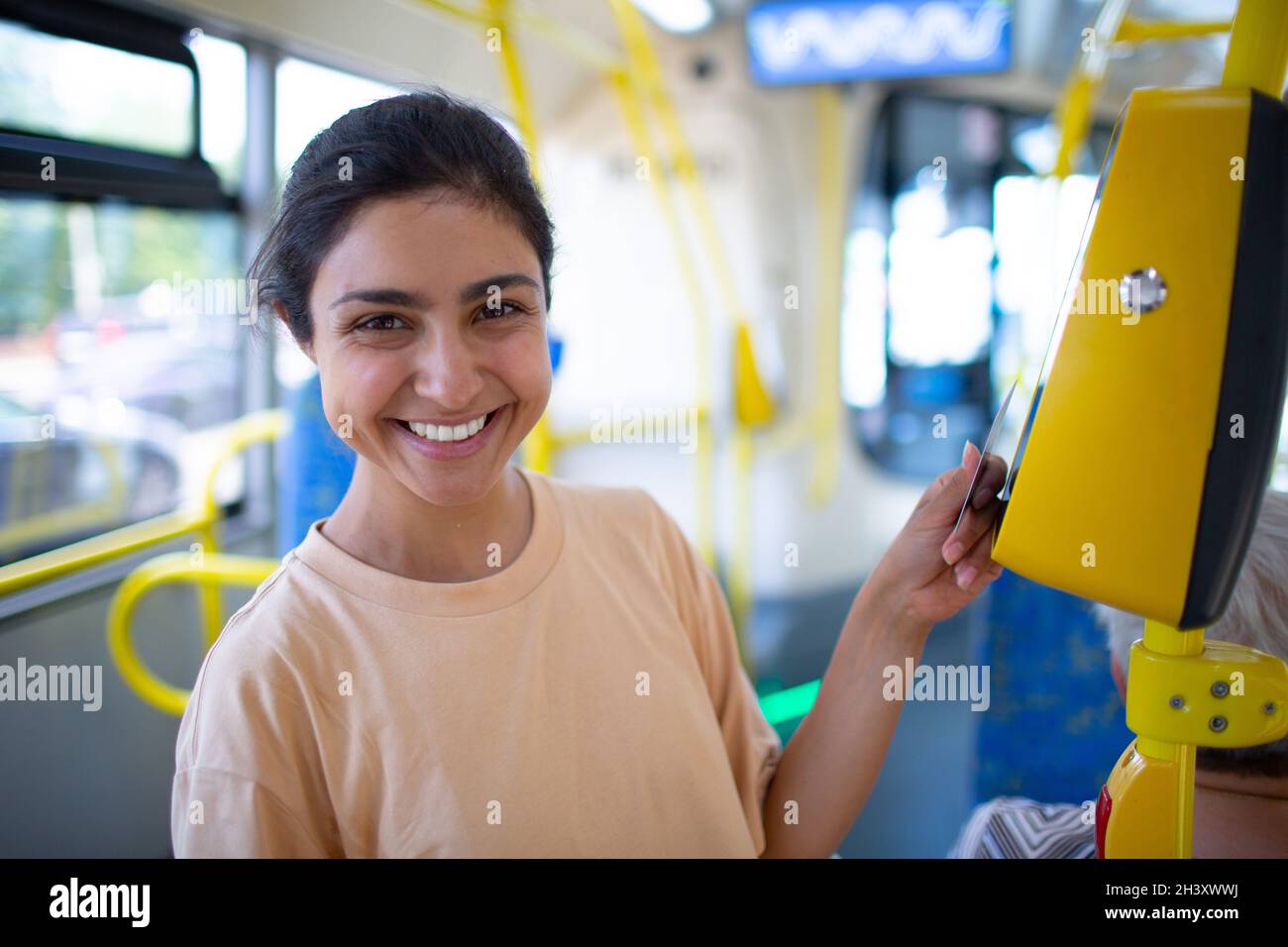 Frau Zahlung conctactless mit Smartphone für die öffentlichen Verkehrsmittel in der Straßenbahn Stockfoto