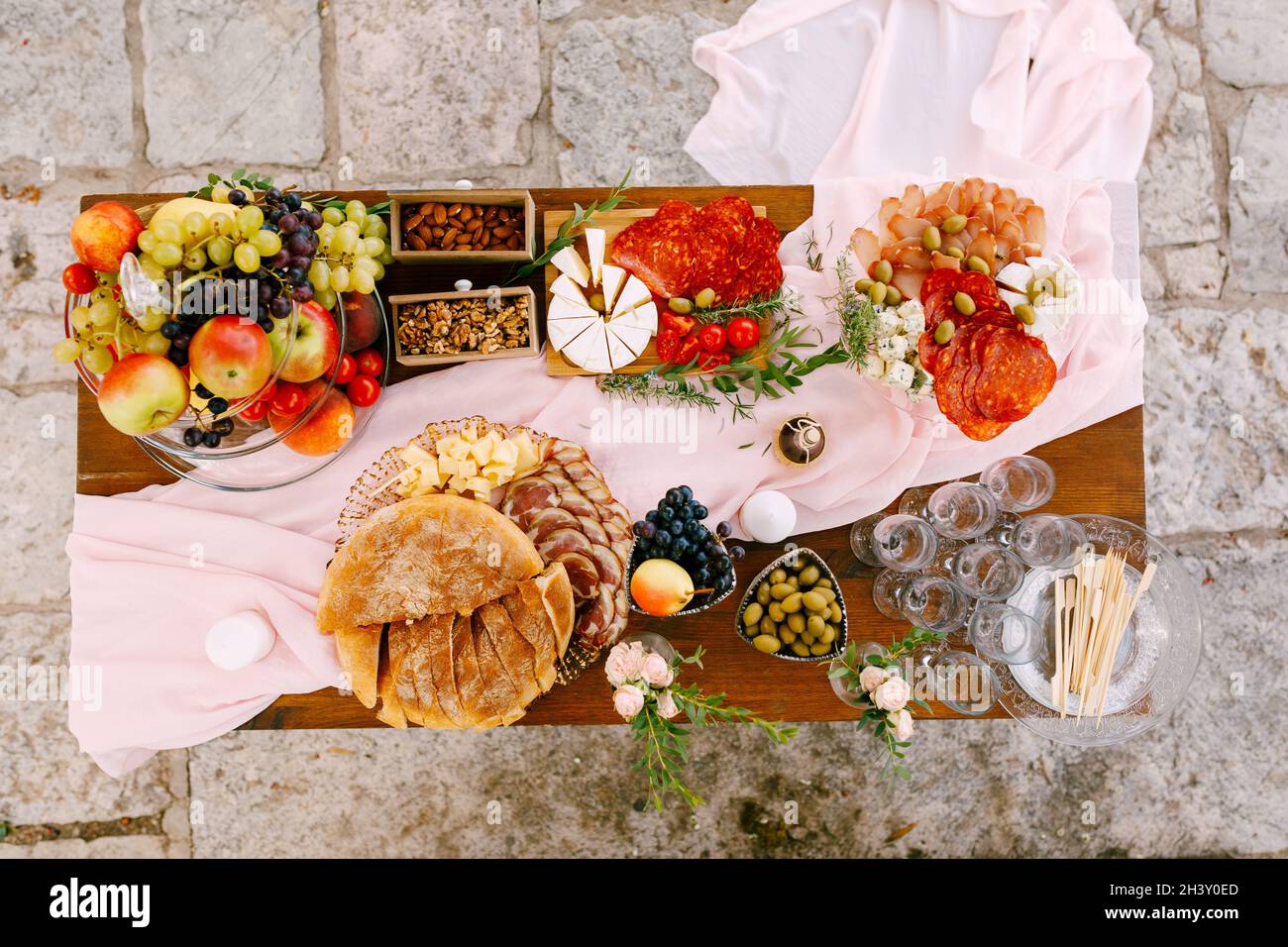 Draufsicht auf einen Tisch mit Köstlichkeiten für die Feier und leeren Gläsern für Champagner. Stockfoto