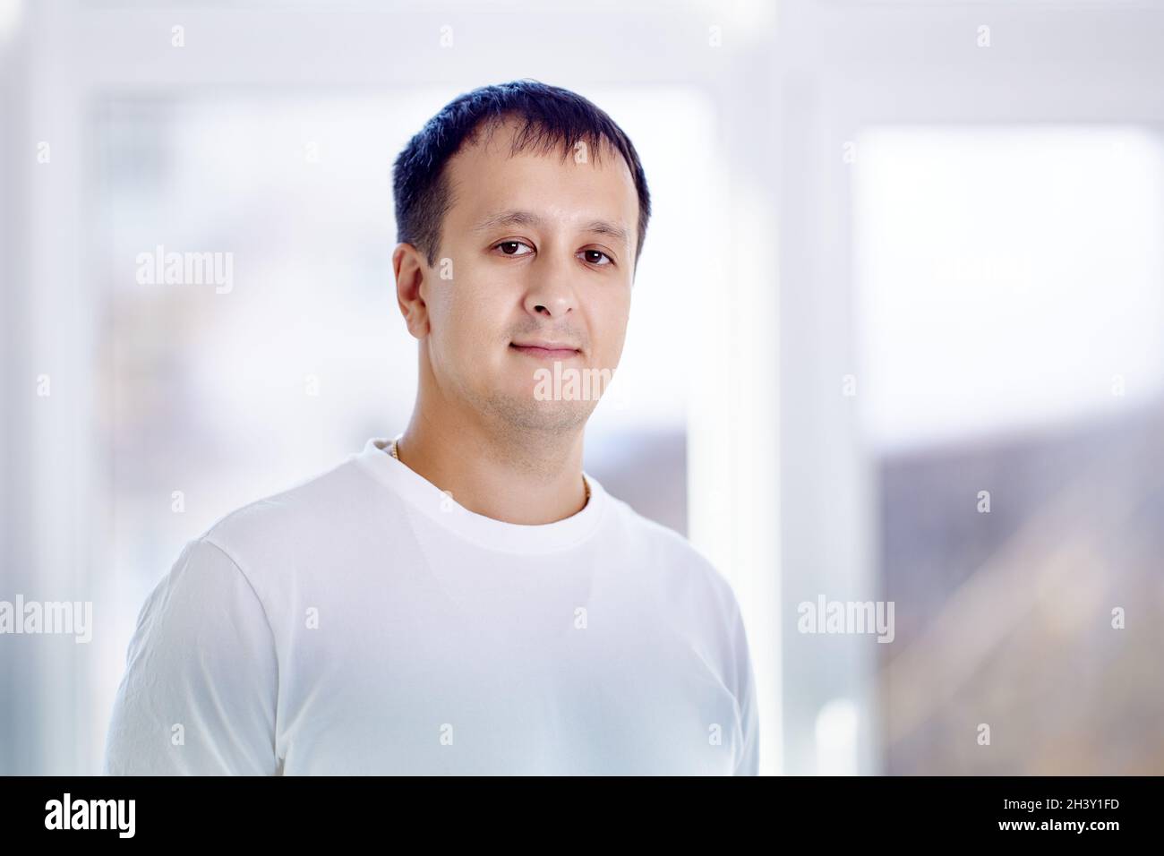 Porträt eines jungen Mannes mit gemischter Rasse, der im Wohnzimmer steht. Stockfoto