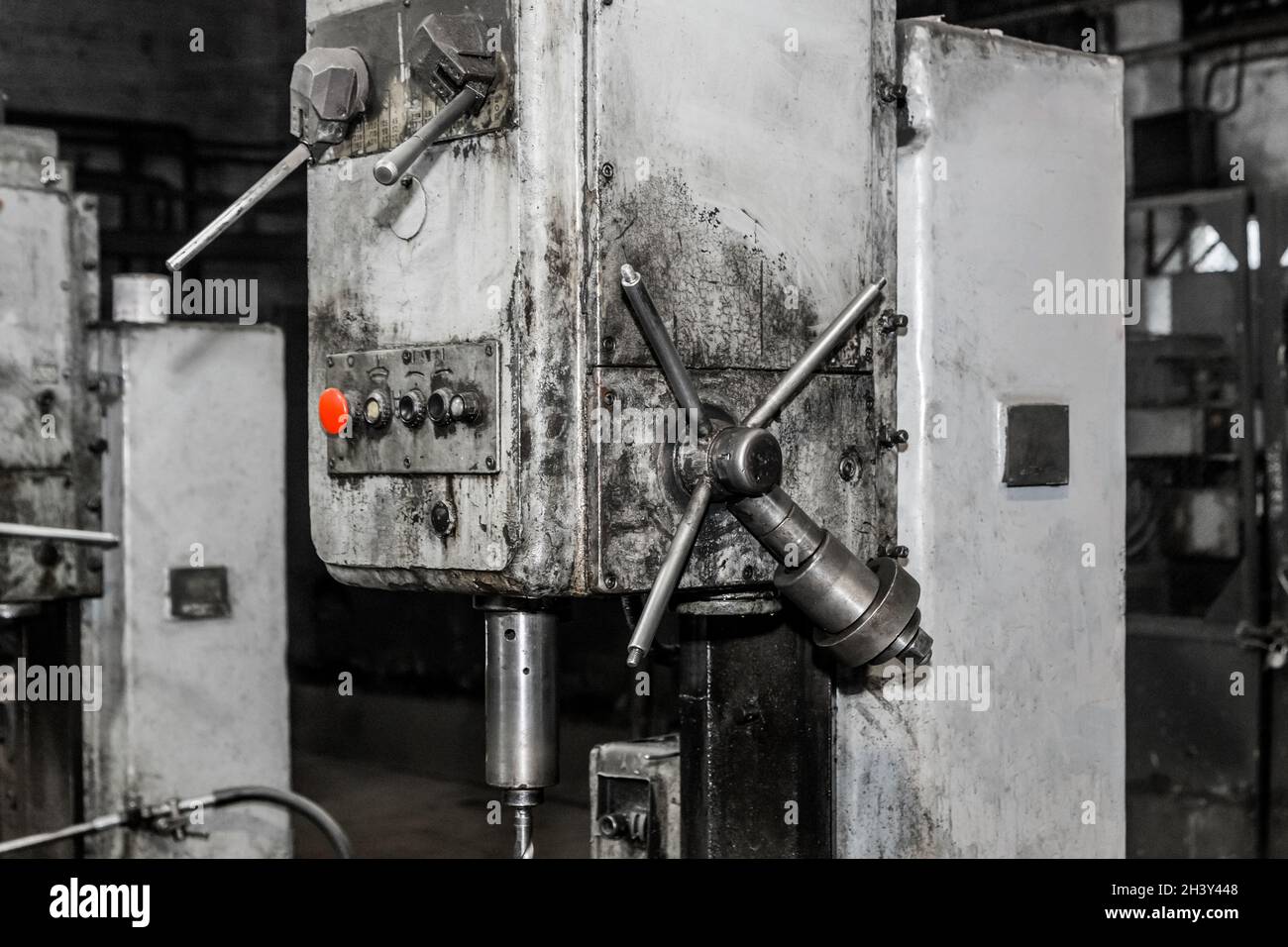 Teil einer alten Fräsmaschine mit Geräten und Werkzeugen für die Metallbearbeitung mit einem Eisengriff in der Werkstatt eines Industriewerks. Stockfoto